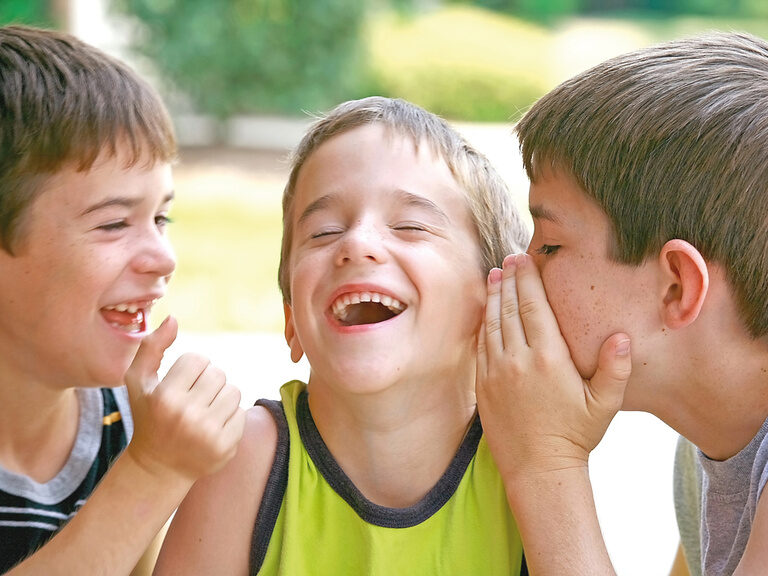 Eine Gruppe von jungen Buben lacht gemeinsam in einem lustigen Moment.